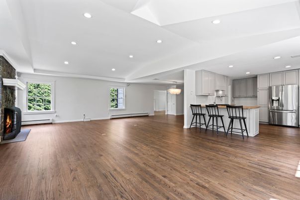Empty room, Fireplace, Interior, Kitchen, Pendant Lights, Recessed Lighting, Stainless Steel Appliances, Wood Texture Flooring