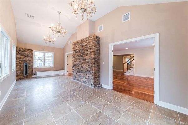 Chandelier, Empty room, Fireplace, Interior, Recessed Lighting, Stone Walls, Wood Texture Flooring
