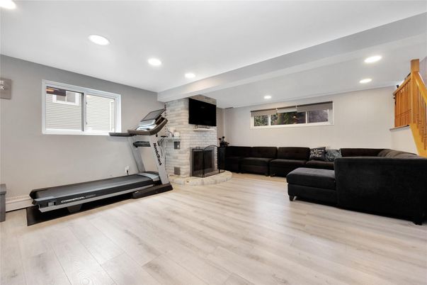 Fireplace, Fitness Equipment, Interior, Living room, Recessed Lighting, Stone Walls, Wood Texture Flooring