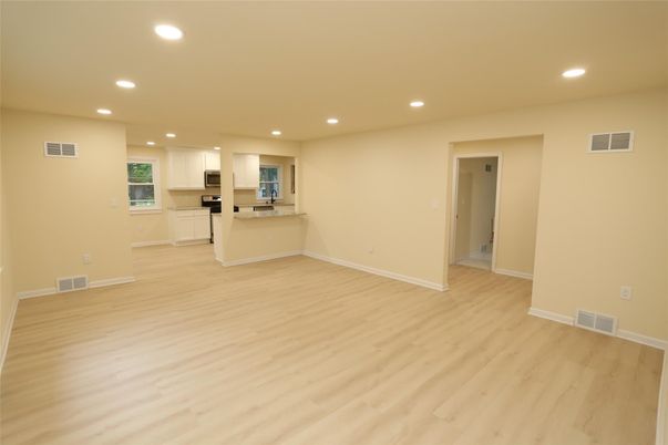 Empty room, Interior, Kitchen, Recessed Lighting, Stainless Steel Appliances, Wood Texture Flooring