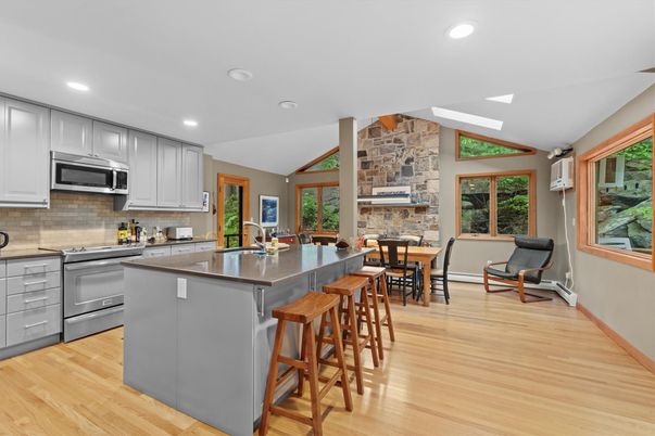 Dining room, Fireplace, Interior, Kitchen, Recessed Lighting, Stainless Steel Appliances, Stone Walls, Wood Texture Flooring