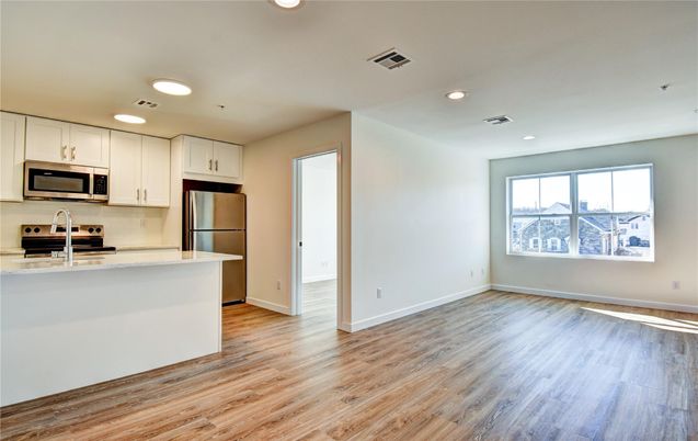 Empty room, Interior, Kitchen, Recessed Lighting, Stainless Steel Appliances, Wood Texture Flooring