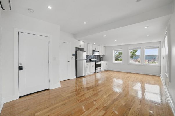Empty room, Interior, Kitchen, Recessed Lighting, Stainless Steel Appliances, Wood Texture Flooring