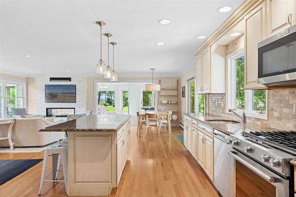 Chandelier, Dining room, Interior, Kitchen, Living room, Pendant Lights, Recessed Lighting, Stainless Steel Appliances, Stone Walls, Wood Texture Flooring