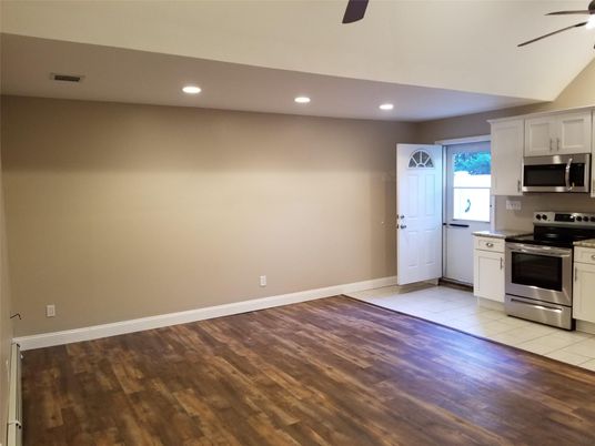 Empty room, Interior, Kitchen, Recessed Lighting, Stainless Steel Appliances, Wood Texture Flooring