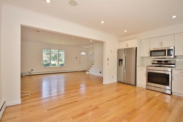 Empty room, Interior, Kitchen, Recessed Lighting, Stainless Steel Appliances, Wood Texture Flooring