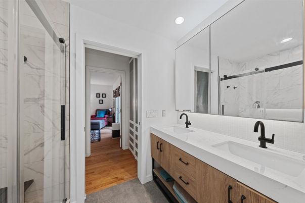 Bathroom, Dual Sink Vanities, Glass Shower, Interior, Marble Walls, Recessed Lighting, Wood Texture Flooring