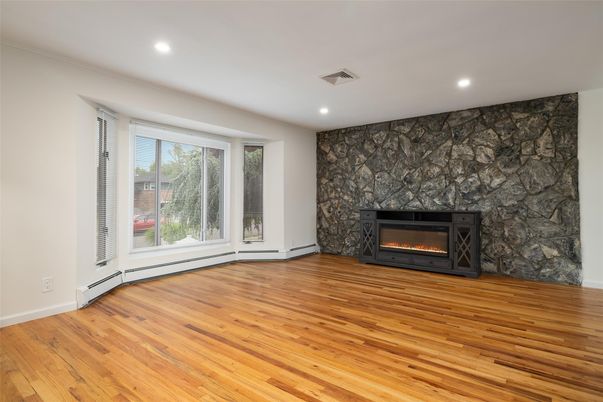 Empty room, Fireplace, Interior, Recessed Lighting, Stone Walls, Wood Texture Flooring