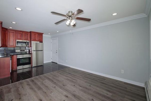 Empty room, Interior, Kitchen, Recessed Lighting, Stainless Steel Appliances, Wood Texture Flooring