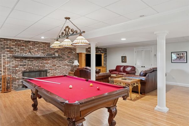 Billiard Table, Chandelier, Fireplace, Game Room, Interior, Living room, Recessed Lighting, Stone Walls, Wood Texture Flooring