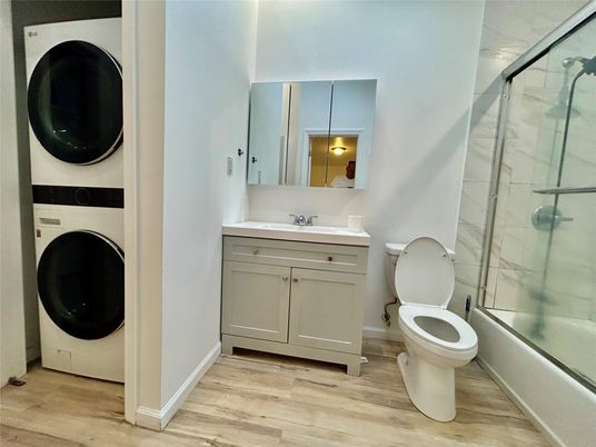 Bathroom, Glass Shower, Interior, Washer, Wood Texture Flooring