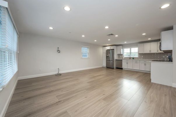 Empty room, Interior, Kitchen, Recessed Lighting, Stainless Steel Appliances, Wood Texture Flooring