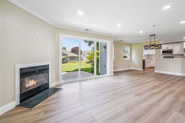 Empty room, Fireplace, Interior, Kitchen, Pendant Lights, Recessed Lighting, Stainless Steel Appliances, Wood Texture Flooring