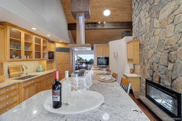 Dining room, Fireplace, Interior, Kitchen, Recessed Lighting, Stainless Steel Appliances, Stone Walls, Wooden Ceilings