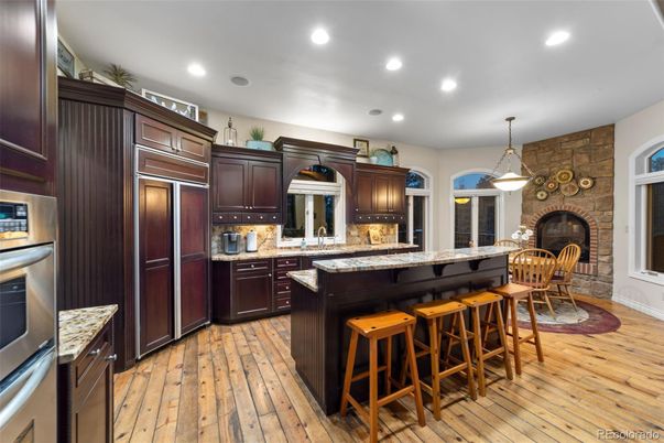 Fireplace, Interior, Kitchen, Pendant Lights, Recessed Lighting, Stainless Steel Appliances, Stone Walls, Wood Texture Flooring