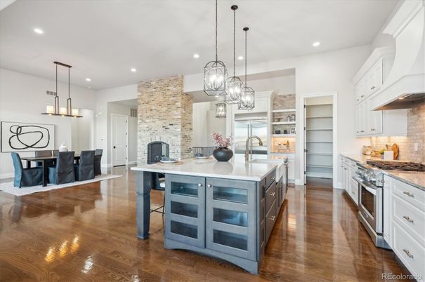 Dining room, Fireplace, Interior, Kitchen, Pendant Lights, Recessed Lighting, Stainless Steel Appliances, Stone Walls, Wood Texture Flooring