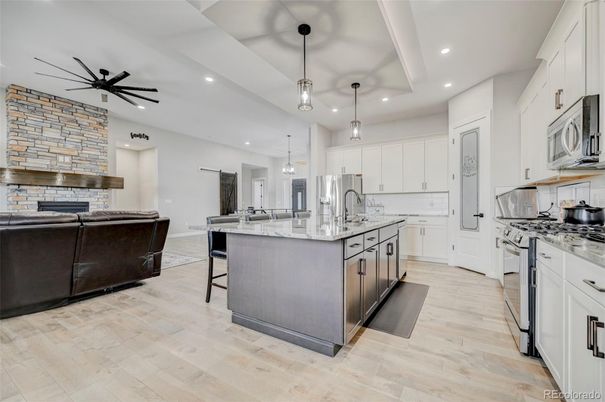 Fireplace, Interior, Kitchen, Living room, Pendant Lights, Recessed Lighting, Stainless Steel Appliances, Stone Walls, Wood Texture Flooring