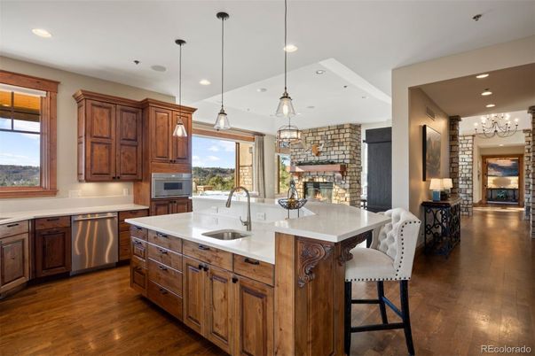 Fireplace, Interior, Kitchen, Pendant Lights, Recessed Lighting, Stainless Steel Appliances, Stone Walls, Wood Texture Flooring