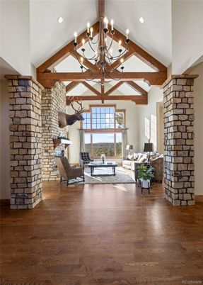Chandelier, Fireplace, Interior, Living room, Recessed Lighting, Stone Walls, Wooden Beams, Wood Texture Flooring