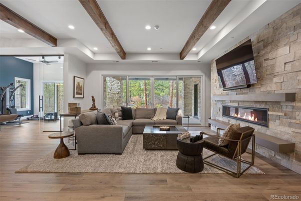 Fireplace, Fitness Equipment, Interior, Living room, Recessed Lighting, Stone Walls, Wooden Beams, Wood Texture Flooring
