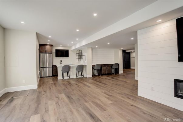 Empty room, Fireplace, Interior, Kitchen, Recessed Lighting, Stainless Steel Appliances, Wood Texture Flooring