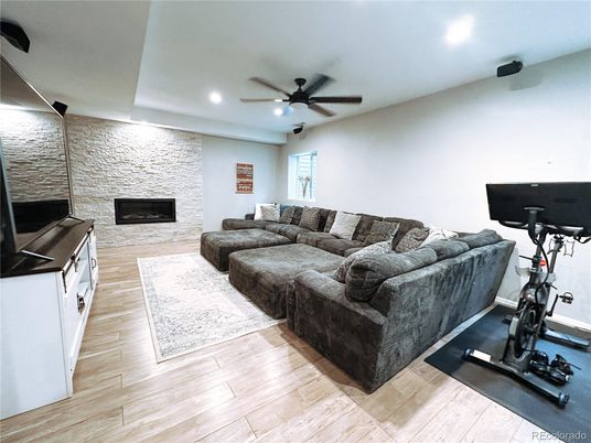 Fireplace, Fitness Equipment, Interior, Living room, Recessed Lighting, Stone Walls, Wood Texture Flooring