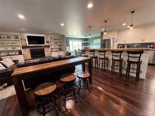 Dining room, Fireplace, Interior, Kitchen, Pendant Lights, Recessed Lighting, Stainless Steel Appliances, Stone Walls, Wood Texture Flooring