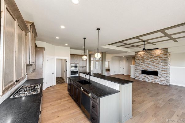 Fireplace, Interior, Kitchen, Pendant Lights, Recessed Lighting, Stainless Steel Appliances, Stone Walls, Wood Texture Flooring