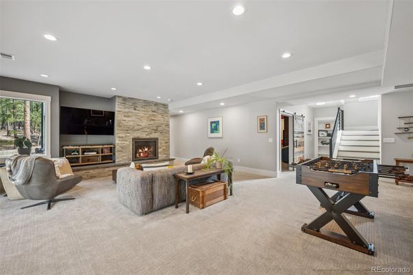 Fireplace, Game Room, Interior, Living room, Recessed Lighting, Stone Walls, Wood Texture Flooring