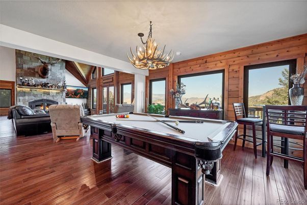 Billiard Table, Chandelier, Fireplace, Game Room, Interior, Living room, Stone Walls, Wood Texture Flooring, Wooden Walls