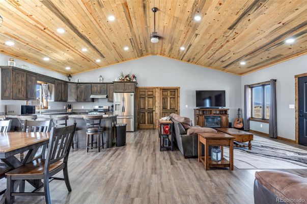 Dining room, Fireplace, Interior, Kitchen, Living room, Recessed Lighting, Stainless Steel Appliances, Wooden Ceilings, Wood Texture Flooring