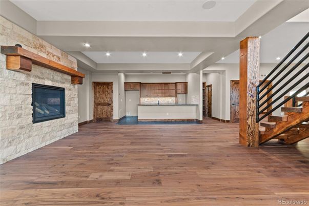 Empty room, Fireplace, Interior, Kitchen, Recessed Lighting, Stone Walls, Wood Texture Flooring