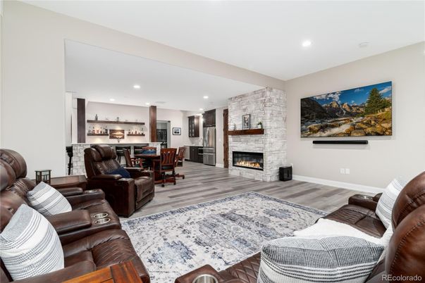 Dining room, Fireplace, Interior, Living room, Recessed Lighting, Stone Walls, Wood Texture Flooring