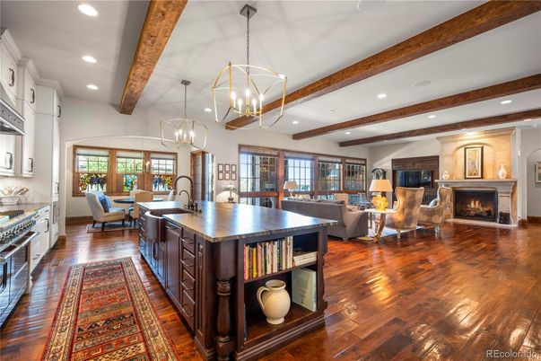 Chandelier, Dining room, Fireplace, Interior, Kitchen, Living room, Pendant Lights, Recessed Lighting, Stainless Steel Appliances, Wooden Beams, Wood Texture Flooring