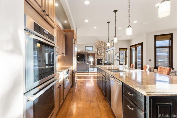 Fireplace, Interior, Kitchen, Pendant Lights, Recessed Lighting, Stainless Steel Appliances, Stone Walls, Wood Texture Flooring