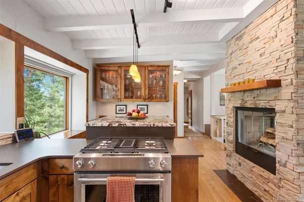 Fireplace, Interior, Kitchen, Pendant Lights, Stainless Steel Appliances, Stone Walls, Wood Texture Flooring
