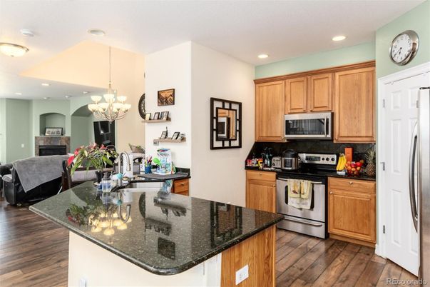 Chandelier, Dining room, Fireplace, Interior, Kitchen, Living room, Recessed Lighting, Stainless Steel Appliances, Wood Texture Flooring