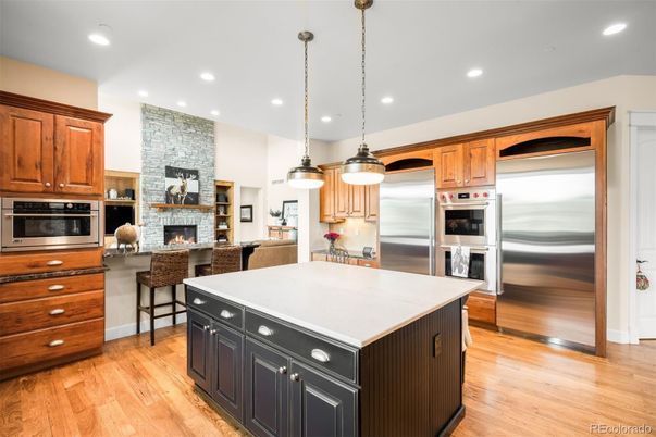 Fireplace, Interior, Kitchen, Pendant Lights, Recessed Lighting, Stainless Steel Appliances, Stone Walls, Wood Texture Flooring