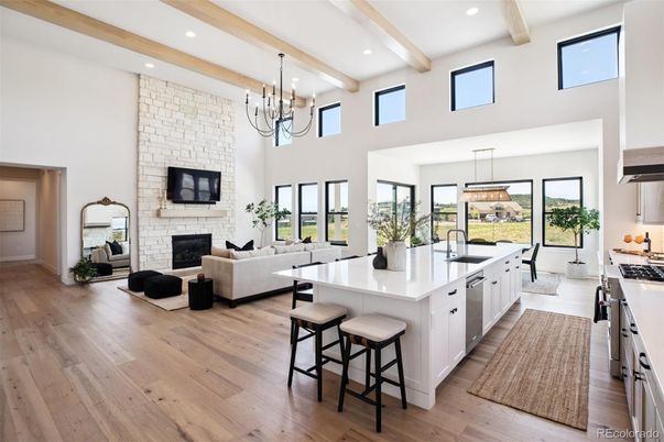 Chandelier, Dining room, Fireplace, Interior, Kitchen, Living room, Pendant Lights, Recessed Lighting, Stainless Steel Appliances, Stone Walls, Wooden Beams, Wood Texture Flooring