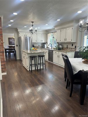 Chandelier, Dining room, Interior, Kitchen, Recessed Lighting, Stainless Steel Appliances, Stone Walls, Wood Texture Flooring
