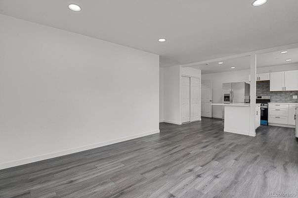 Empty room, Interior, Kitchen, Recessed Lighting, Stainless Steel Appliances, Wood Texture Flooring
