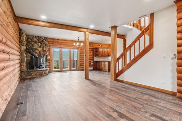 Chandelier, Empty room, Fireplace, Interior, Recessed Lighting, Stone Walls, Wooden Beams, Wood Texture Flooring, Wooden Walls