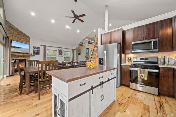 Dining room, Fireplace, Interior, Kitchen, Recessed Lighting, Stainless Steel Appliances, Stone Walls, Wood Texture Flooring