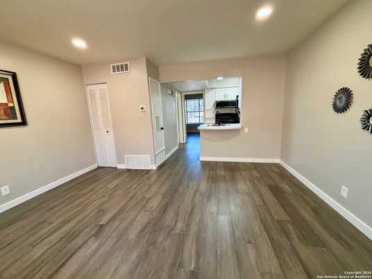 Empty room, Interior, Kitchen, Recessed Lighting, Stainless Steel Appliances, Wood Texture Flooring