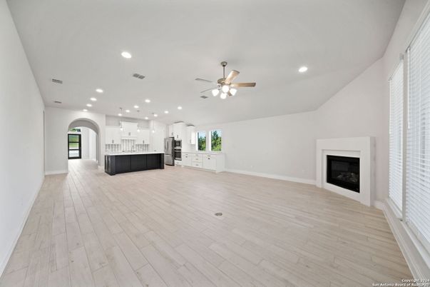 Empty room, Fireplace, Interior, Kitchen, Pendant Lights, Recessed Lighting, Stainless Steel Appliances, Wood Texture Flooring