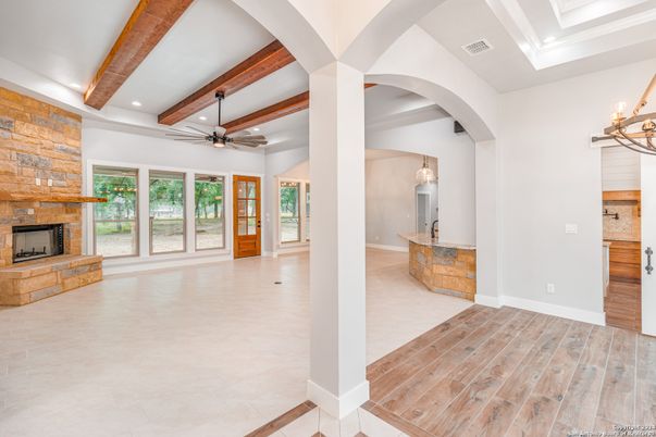 Chandelier, Empty room, Fireplace, Interior, Pendant Lights, Recessed Lighting, Stone Walls, Wooden Beams, Wood Texture Flooring