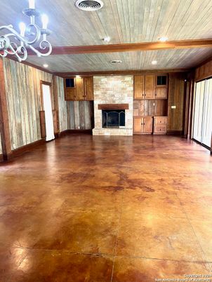 Chandelier, Empty room, Fireplace, Interior, Recessed Lighting, Stone Walls, Wood Texture Flooring