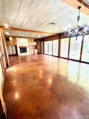 Chandelier, Empty room, Fireplace, Interior, Recessed Lighting, Stone Walls, Wooden Ceilings