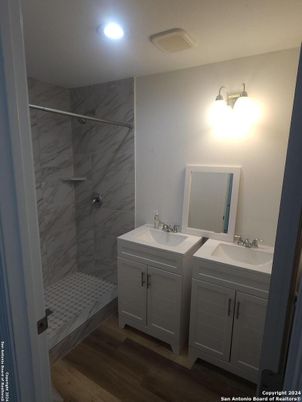 Bathroom, Dual Sink Vanities, Interior, Marble Walls, Recessed Lighting, Wood Texture Flooring