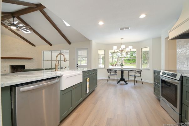 Chandelier, Dining room, Fireplace, Interior, Kitchen, Pendant Lights, Recessed Lighting, Stainless Steel Appliances, Stone Walls, Wooden Beams, Wood Texture Flooring